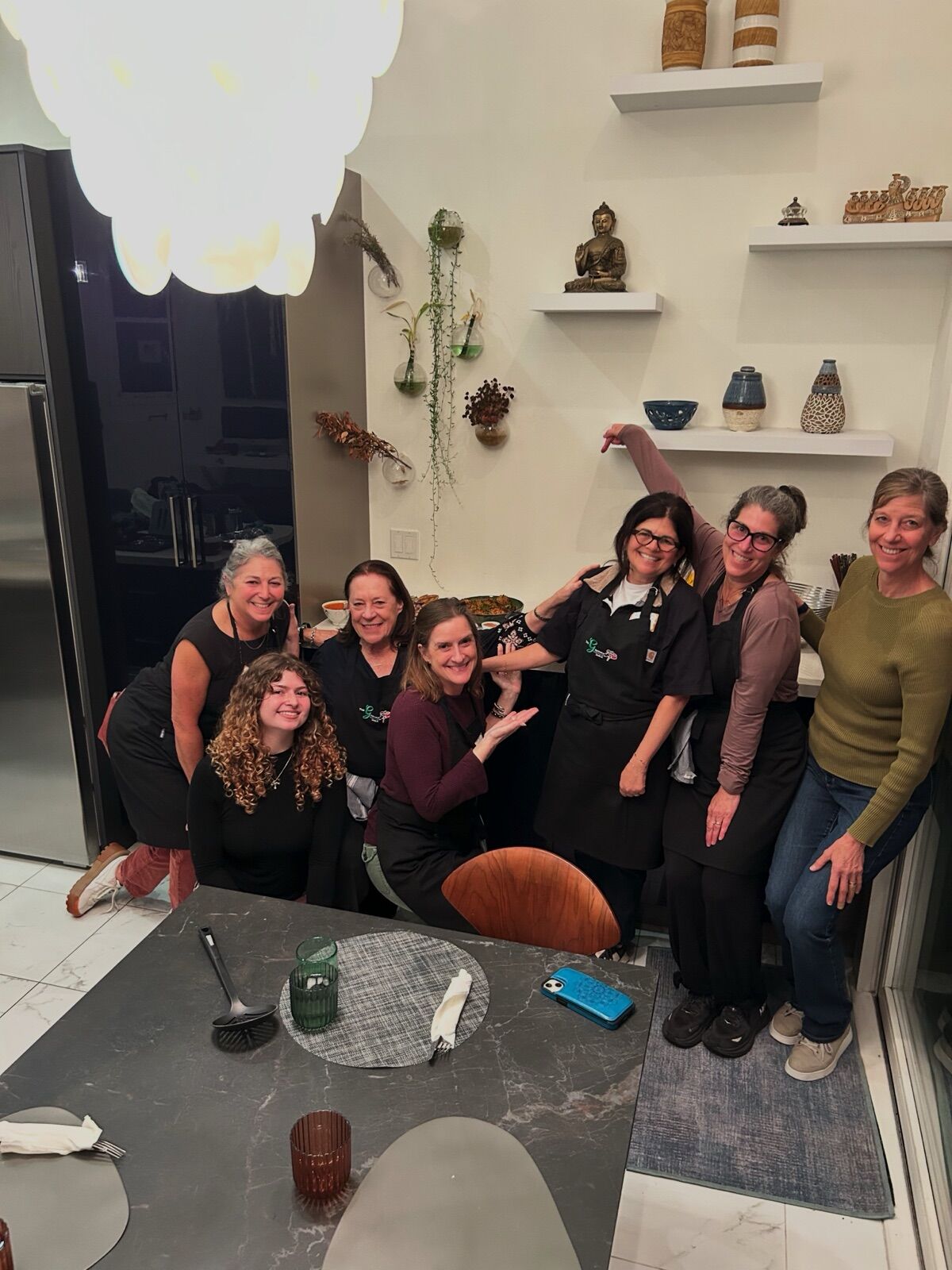 A Crew striking playful poses around the kitchen table