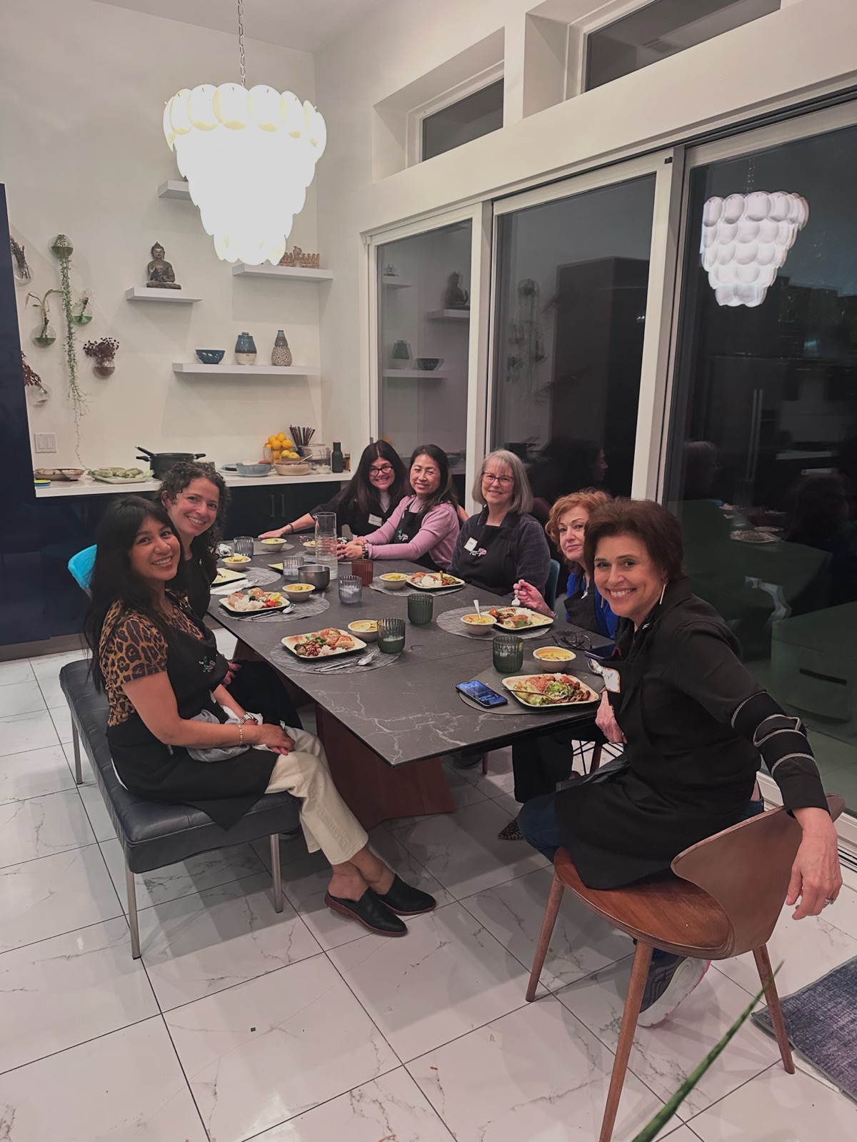 A Crew seated around the long table sharing the meal they cooked
