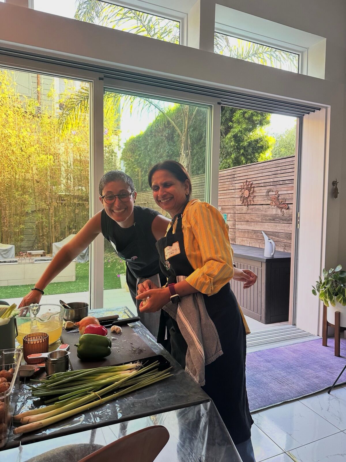 Two guests prepping vegetables together by a sunny window
